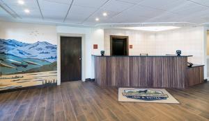 an office with a reception desk and a large painting on the wall at Gray Wolf Inn & Suites in West Yellowstone +37 photos