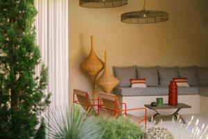 a living room with a couch and chairs and a table at MARCELLE EN CAMARGUE - intra muros - piscine et jardin - petit déjeuner compris in Aigues-Mortes