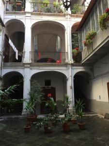 un cortile con piante in vaso e balconi in un edificio di Don Vincenzo's home a Napoli