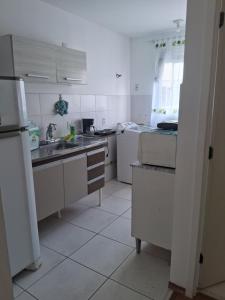 a kitchen with white cabinets and a sink at Apto Oeste simples Santa cruz in Santa Cruz