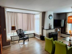 a living room with a table and chairs and a television at Texelheerlijk 4 in De Koog