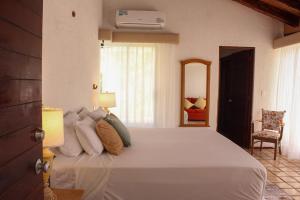 a bedroom with a large white bed and a chair at Ocean Bloom in Cancún