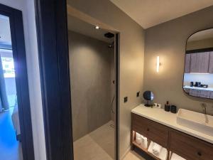 a bathroom with a shower and a sink and a mirror at Eleni Village & Suites in Amoudara Herakliou +21 photos