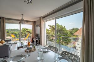 a dining room with a table and a large window at Plage Centrale in Soorts-Hossegor
