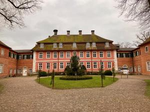 a large red brick building with a green roof at Hotel Seeblick garni in Gartow