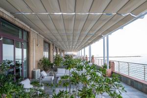 a patio with chairs and plants on a building at Hotel Centro Congressi Polo Nautico in Salerno