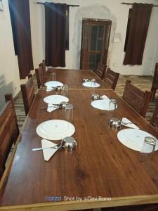 a large wooden table in a room with chairs at Dayara resort in Bhatwāri