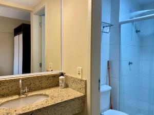 a bathroom with a sink and a toilet and a mirror at Flat em Frente a USP - Centrinho - CPO - Sem Garagem in Bauru +62 photos