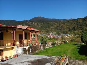 a house with a yard with a view of a mountain at Dayara resort in Bhatwāri