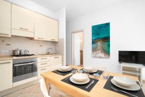a kitchen with a wooden table with white cabinets at Excelsior - Venturina Terme in Venturina Terme