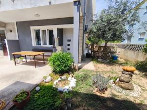 a backyard with a table and a miniature garden at Ora Apartment in Kastel Sucurac