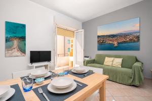 a living room with a table and a green couch at Excelsior - Venturina Terme in Venturina Terme