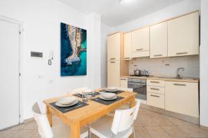 a kitchen with a wooden table and white cabinets at Excelsior - Venturina Terme in Venturina Terme +2 photos