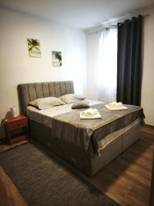 a bedroom with a large bed with two towels on it at Ora Apartment in Kastel Sucurac