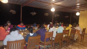 a group of people sitting at a table eating at Dayara resort in Bhatwāri +38 photos