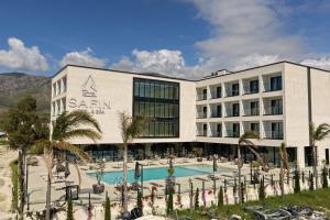 a hotel with a swimming pool and palm trees at Safin Hotel & Spa in Vlorë