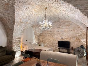a living room with a stone wall and a chandelier at Appartamento San Giorgio in Bitonto