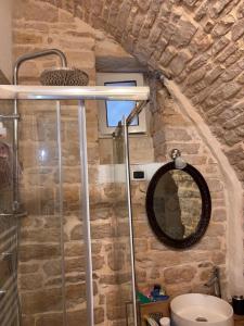 a bathroom with a stone wall and a mirror at Appartamento San Giorgio in Bitonto