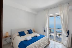 a bedroom with a bed with blue pillows and a window at Villa Azzurra in Massa Lubrense +192 photos