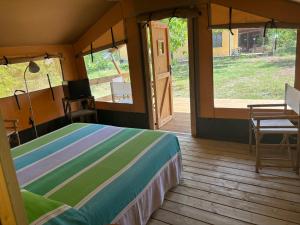 a bedroom with a bed and a wooden deck at Vulture Glamping in Melfi