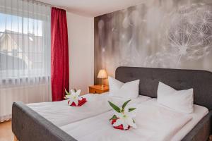 a bedroom with a bed with two flowers on it at Waldsiedlung Waldhaus App 4.2 in Korswandt