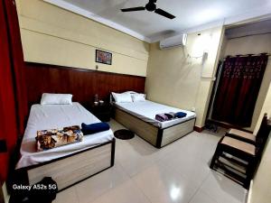 a room with two beds and a chair in it at Hotel Swagat in Itahari