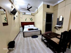 a bedroom with a bed and a bench in it at Hotel Swagat in Itahari