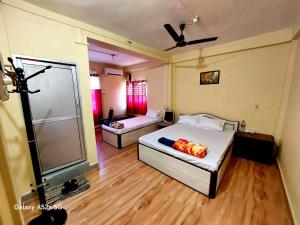 a room with two beds and a shower in it at Hotel Swagat in Itahari +8 photos
