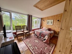 a bedroom with a bed and a desk and a television at Auberge Maison Gauthier in Tadoussac
