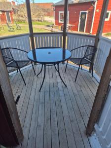 a patio table and two chairs on a deck at lillstugan in Avesta