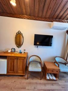 a living room with two chairs and a tv on the wall at Duru Hanım Konağı in Bursa