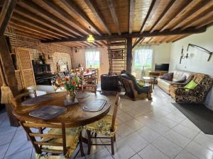 a living room with a wooden table and chairs at Le p'tit bourquin in Bourg-Fidèle