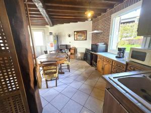 a kitchen with a table and a dining room at Le p'tit bourquin in Bourg-Fidèle +11 photos