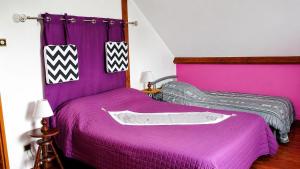 a purple bed with a purple bedspread at Le p'tit bourquin in Bourg-Fidèle