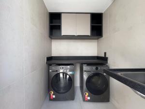 a laundry room with a washer and dryer at Hub by Hosppedar in Cabedelo