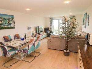a living room with a table and chairs and a couch at Ocean Seven in Newquay