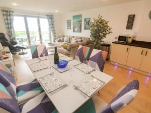 a dining room and living room with a table and chairs at Ocean Seven in Newquay