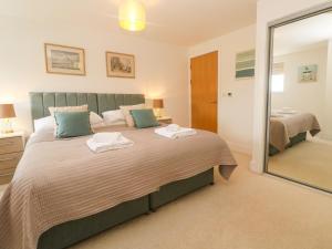 a bedroom with a large bed and a mirror at Ocean Seven in Newquay