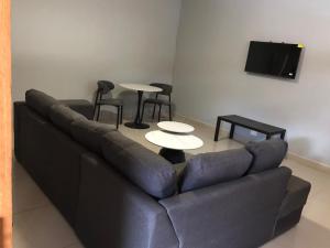 a living room with a couch and tables and a flat screen tv at Leeba Apartments in Maseru
