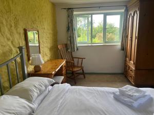 a bedroom with a bed and a desk and a window at Wren Cottage in Cowbridge