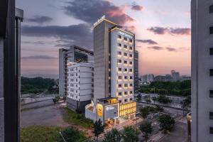 a tall white building with a sunset in the background at Hotel Coolstay Lions Park Daegu February Hotel Lions Park in Daegu