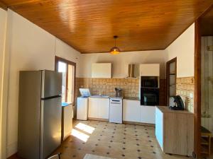 a kitchen with white appliances and a wooden ceiling at Casa d'Eva in Pont-en-Royans