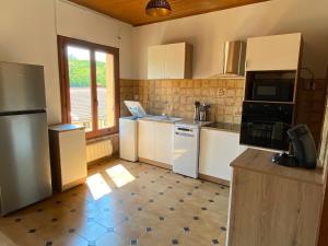 a kitchen with white appliances and a large window at Casa d'Eva in Pont-en-Royans