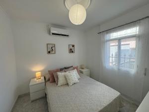 a white bedroom with a bed and a window at SotQui Cedeira in Cedeira