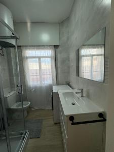 a bathroom with a sink and a toilet and a mirror at SotQui Cedeira in Cedeira