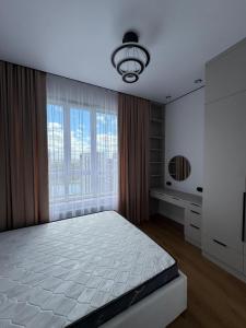 a bedroom with a bed and a large window at NewCityLife in Astana