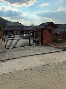a building with a gate in front of a house at Leeba Apartments in Maseru