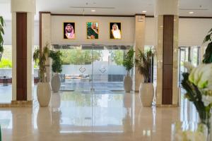 a lobby with a hallway with plants and pictures on the walls at The District Hotel Najran in Najran +54 photos