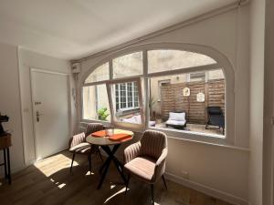 a room with a table and chairs and a window at Charmant studio avec terrasse in Fécamp