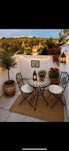 a table and two chairs on a balcony with plants at Casa Abuela Dolores in Setenil